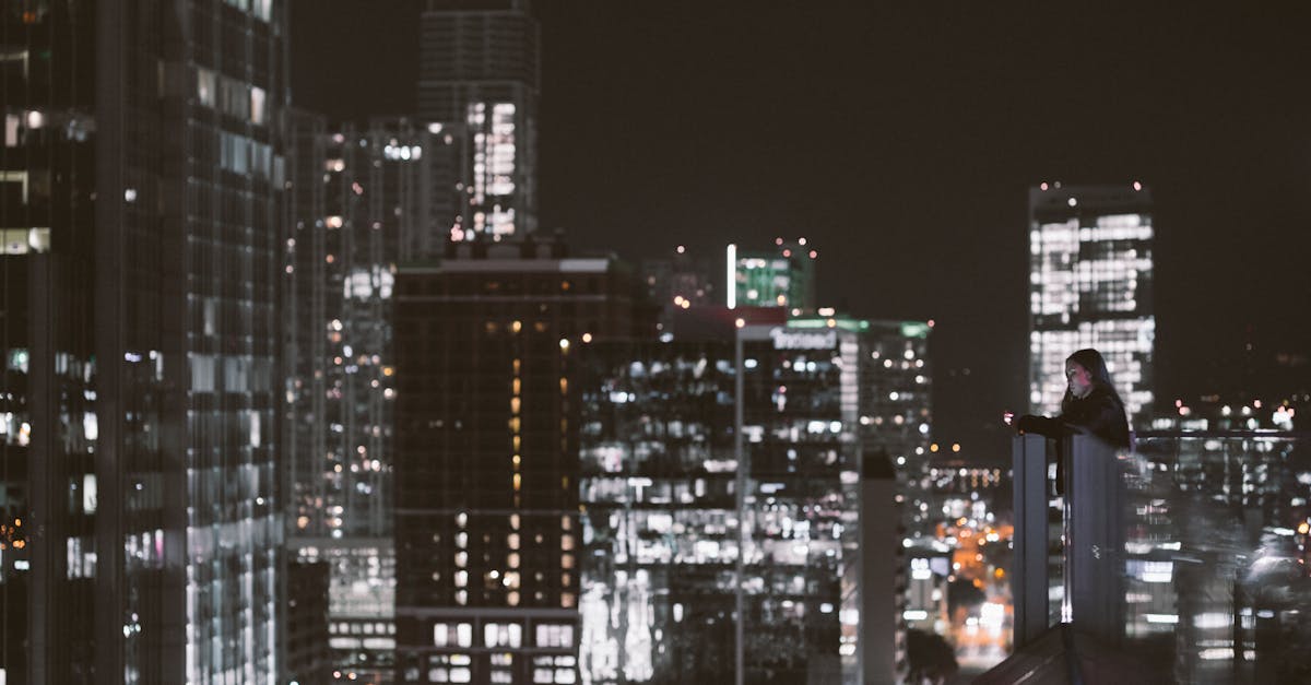 woman sitting alone balcony city lights evening