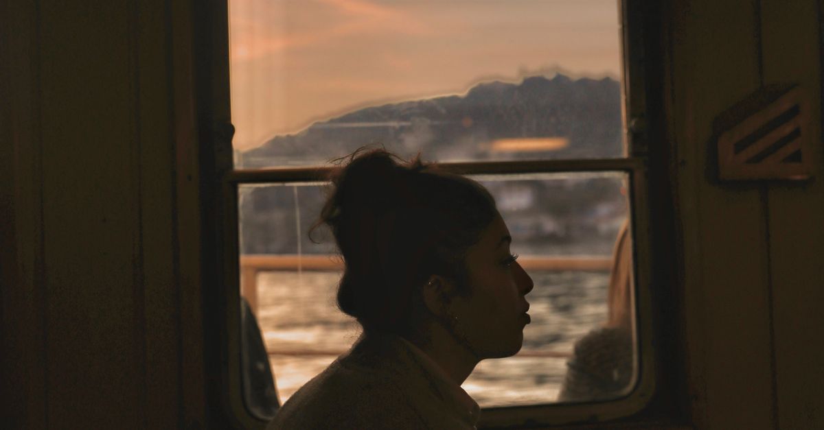 woman sitting alone window evening