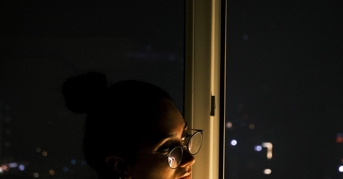 woman alone apartment night city lights